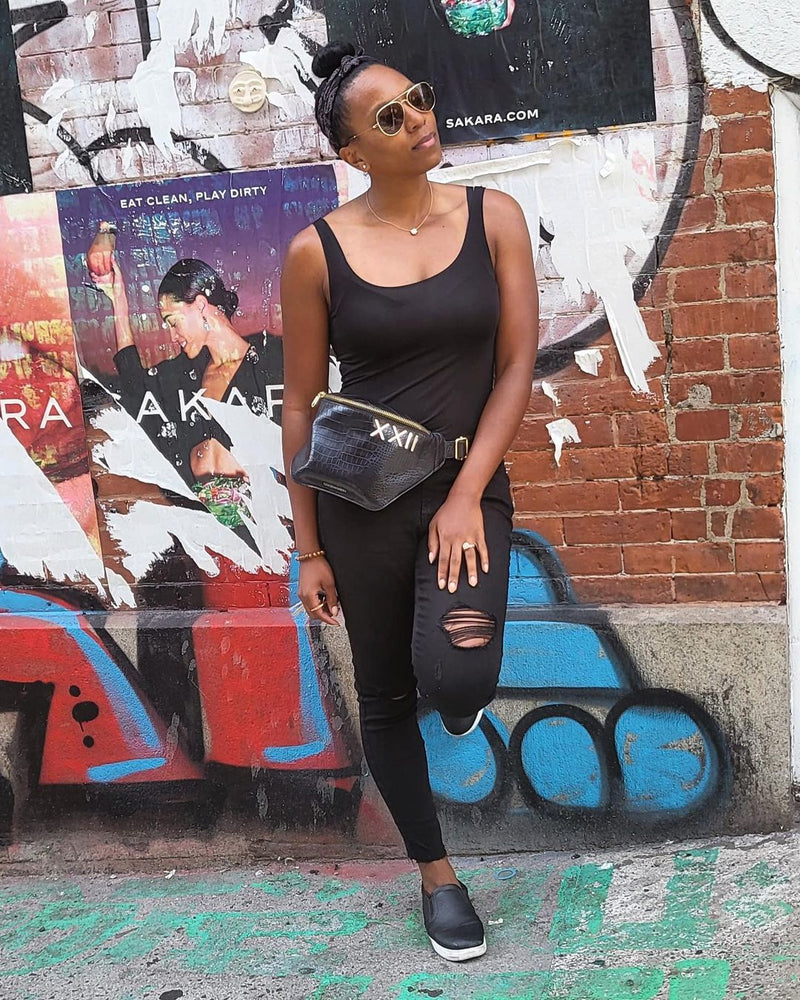 Black influencer wearing our best seller black and gold fanny pack.