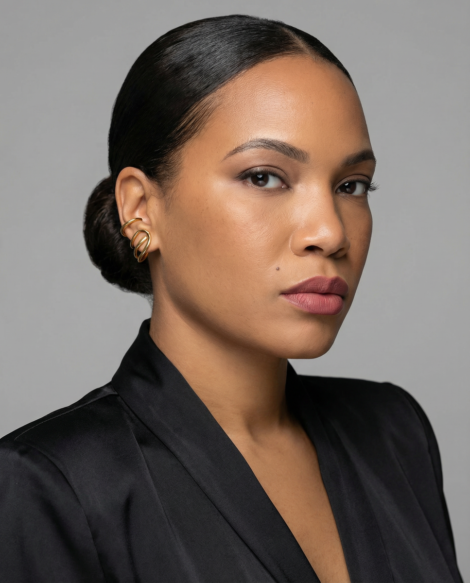 Woman with styled hair wearing a black top against a gray background
